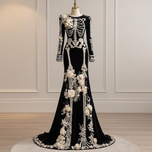 May include: A floor-length black velvet gown featuring long sleeves and a white skeletal bone design across the bodice and arms. The dress is embellished with three-dimensional white fabric flowers and leaf accents cascading down the front.