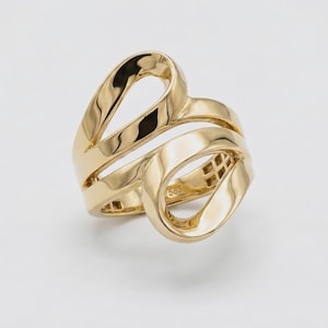 May include: A polished yellow gold ring featuring a continuous, fluid design with open, looping bands that create a layered, sculptural appearance. The inner band of the ring is clearly stamped with the hallmark 585, indicating its gold purity.