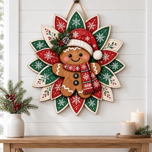 Könnte beinhalten: Ein dekorativer Wandschmuck mit einem Lebkuchenmann in der Mitte, der eine rote Weihnachtsmütze und einen rot-grünen Schal trägt. Die Figur ist von einem sternförmigen Rahmen aus roten und grünen Holzblütenblättern mit weißen Schneeflocken umgeben.