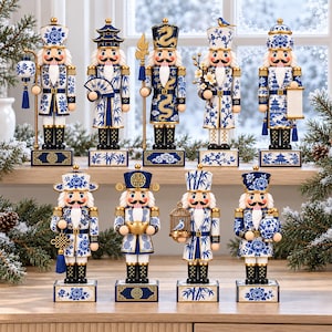 Könnte beinhalten: Eine Sammlung von neun Nussknacker-Figuren mit blau-weißen Porzellanmustern. Jede Figur trägt eine Uniform mit floralen, Bambus- oder Drachenmotiven und steht auf einem rechteckigen Sockel mit goldenen Akzenten und verschiedenen Accessoires.