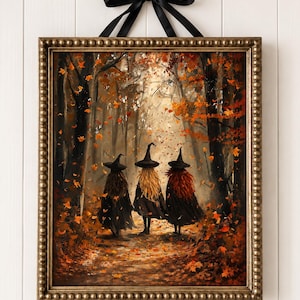 May include: A framed wall art piece depicting three figures wearing black pointed hats and dark cloaks walking through an autumn forest filled with falling orange and brown leaves. The rectangular frame has a beaded texture and a black ribbon.