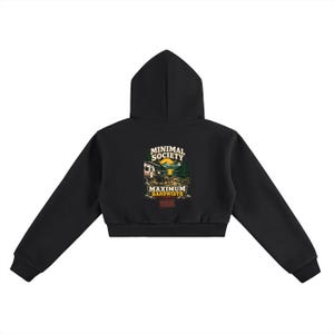 May include: A black cropped hoodie featuring a graphic on the back. The design depicts a camping scene with a trailer, mountains, and a sun, with the text MINIMAL SOCIETY and MAXIMUM BANDWIDTH printed in white and yellow above and below the image.