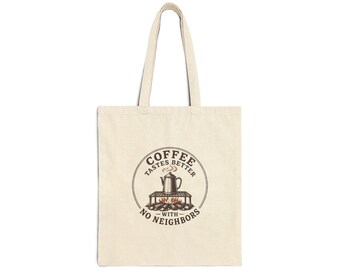 May include: A beige canvas tote bag featuring a circular graphic with a coffee percolator on a campfire grate. The text reads COFFEE TASTES BETTER WITH NO NEIGHBORS. The design uses brown and orange tones to depict the pot, steam, and fire.