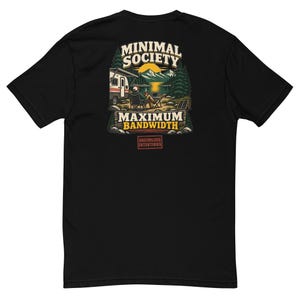 May include: A black t-shirt featuring a graphic on the back. The illustration shows a person sitting in a chair by a camper and a lake, with mountains and trees in the background. Text reads MINIMAL SOCIETY, MAXIMUM BANDWIDTH, and UNCIVILIZED INTENTIONS.