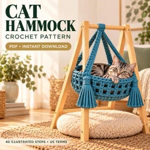 Puede incluir: Un patrón de ganchillo para hamaca de gato en PDF con descarga instantánea. La imagen muestra un gato atigrado descansando en una hamaca de ganchillo azul de hilo grueso, suspendida de un soporte de madera clara en forma de A con borlas.