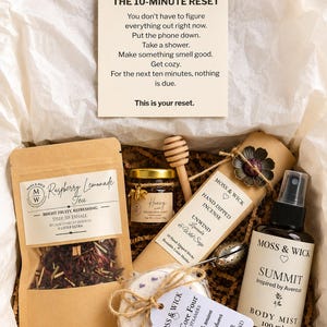 Peut inclure: Un coffret cadeau contenant un sachet de thé Raspberry Lemonade, un petit pot de miel avec une cuillère en bois, un paquet d'encens fait main, un infuseur à thé en métal, une brume corporelle Summit de 100 ml et une pastille de douche.