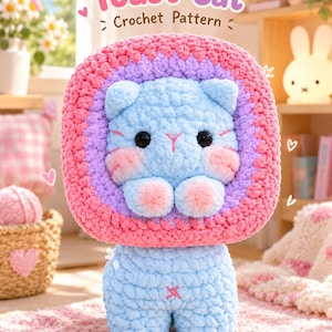 Può includere: Un peluche a forma di gatto all'uncinetto azzurro con una cornice quadrata rosa e viola attorno alla testa. Il gatto ha occhi neri, baffi ricamati rosa e guance rosa. Il testo Toast Cat Crochet Pattern è visualizzato sopra il peluche.