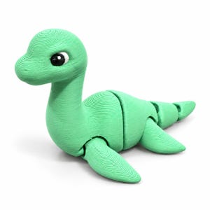 May include: A light green articulated dinosaur figurine with a long neck and a segmented body. The creature features a smooth, rounded head with large black and white eyes and visible horizontal 3D printed layer lines across its entire surface.