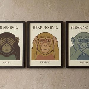 May include: Three framed wall art prints featuring the three wise monkeys. The first shows a dark brown monkey covering its eyes with the text SEE NO EVIL and MIZARU. The second shows a tan monkey covering its ears with HEAR NO EVIL and KIKAZARU. The third shows a grey monkey covering its mouth with SPEAK NO EVIL and IWAZARU.