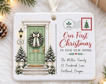 May include: A rectangular white ceramic ornament with a ribbon hanger featuring a green front door with a wreath, two small pine trees, and text reading Our First Christmas IN OUR NEW HOME, The Miller Family, 28 Pinebrook Lane, Portland, Oregon.