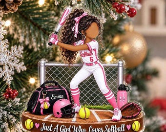 May include: A clear acrylic Christmas ornament featuring a softball player with long brown curly hair, wearing a white and pink uniform with the number 6. It includes a black gear bag labeled Emma, a pink helmet, a bat, and the text Just A Girl Who Loves Softball.
