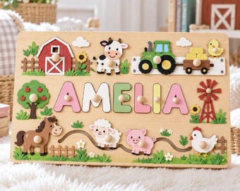 May include: A wooden puzzle board featuring the name AMELIA in colorful letters with knobs. The board displays farm-themed illustrations including a red barn, a green tractor, a horse, a sheep, a pig, a chicken, and a windmill.