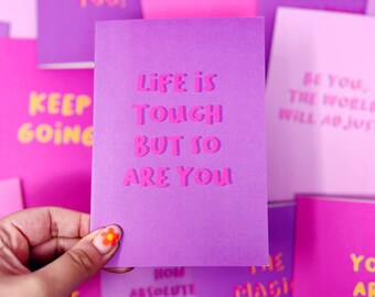 Carte de célébration avec citation motivante « La vie est dure, mais vous l'êtes aussi »
