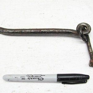 May include: A rusty metal hook with a loop at the end and a screw. The hook is about 7 inches long.