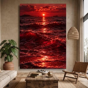 May include: A large rectangular wall art print depicting a vibrant red sunset over a dark ocean. The sun sits low on the horizon, casting a bright, shimmering reflection across the rolling waves and white sea foam in the foreground.