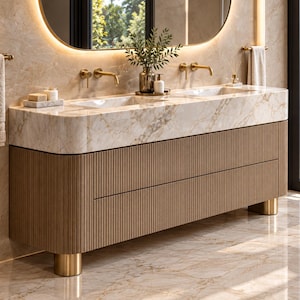 May include: A double vanity featuring a white marble countertop with two integrated sinks, gold faucets, and a light brown wooden cabinet base with vertical fluting. The unit stands on cylindrical gold legs and includes two drawers.