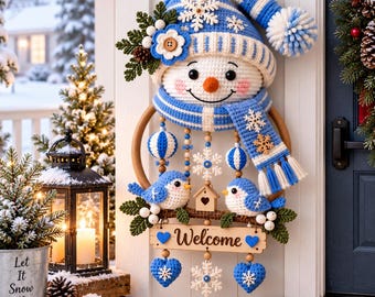 May include: A crochet snowman wall hanging featuring a blue and white striped hat with a pom-pom, a matching scarf, and two blue birds perched on a branch. The piece includes a wooden sign with the word Welcome, hanging hearts, and snowflakes.