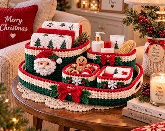 May include: A set of crocheted storage baskets in red, green, and white, featuring a Santa face, a gingerbread man, and snowflake motifs. The baskets are arranged on a large oval tray with a red bow, holding toiletries and small holiday decor.