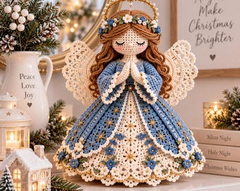 May include: A crocheted angel figurine with long brown hair, a gold halo, and a blue and white dress featuring floral accents and star patterns. The angel has hands clasped in prayer and intricate lace-like wings, standing as a decorative piece.