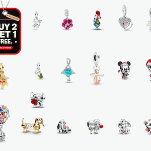 May include: A collection of silver and multi-colored metal charms featuring various characters, flowers, and shapes. The image includes a red rectangular tag with the text BUY 2 GET 1 FREE. MIX & MATCH. The charms depict figures like a house with balloons, animals, and holiday-themed icons.