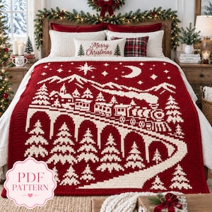 May include: A deep red and cream crochet blanket featuring a winter scene with a steam train traveling across a bridge, pine trees, mountains, a moon, and stars. The text Merry Christmas is printed on a rectangular pillow in the background.