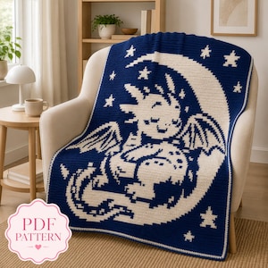 May include: A dark blue and cream crochet blanket featuring a pixelated design of a dragon resting on a crescent moon surrounded by stars. The blanket has a simple border and is draped over a chair. A pink label reads PDF PATTERN.