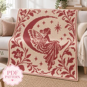 May include: A rectangular crochet blanket featuring a cream-colored base with a dark red pattern. The design depicts a winged figure sitting on a crescent moon surrounded by stars and floral vine borders. A pink label reads PDF PATTERN.
