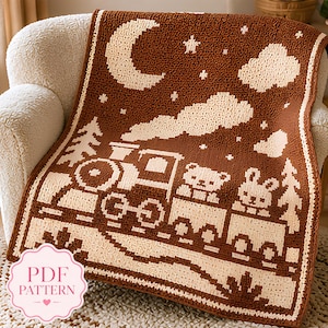 May include: A brown and cream crocheted blanket featuring a pixelated design of a steam train carrying a bear and a rabbit. The scene includes a crescent moon, stars, clouds, and pine trees. A pink label in the corner reads PDF PATTERN.