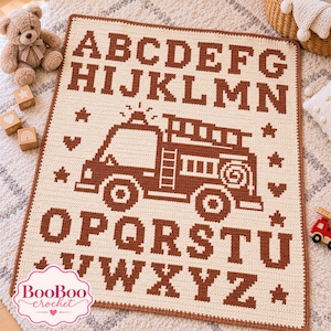 May include: A rectangular crochet blanket featuring a cream-colored background with dark brown lettering of the alphabet from A to Z. The center displays a detailed fire truck graphic, accented by small star and heart motifs throughout.