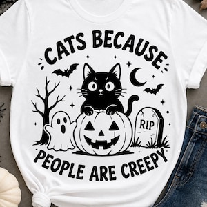 Peut inclure: Un t-shirt blanc à manches courtes avec une impression graphique noire représentant un chat assis sur une citrouille d'Halloween, un fantôme, une pierre tombale avec le texte RIP, des chauves-souris et un arbre. Le texte CATS BECAUSE PEOPLE ARE CREEPY est présent.