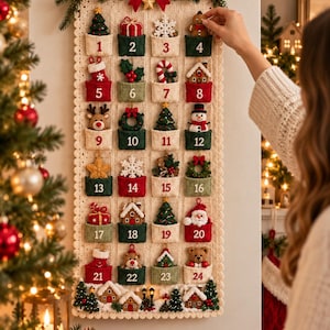 May include: A cream-colored knitted wall-hanging advent calendar featuring twenty-four numbered pockets in red, green, and cream. Each pocket contains a small, detailed holiday-themed ornament, including trees, gifts, snowmen, and bears, topped with a red bow.