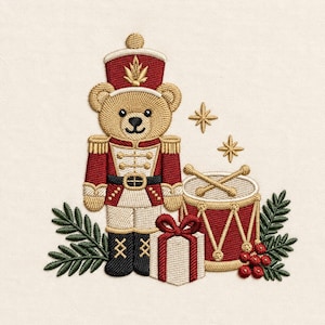 May include: An embroidery design featuring a teddy bear dressed as a nutcracker in a red and gold uniform, standing next to a red drum with gold drumsticks, a white gift box with a red ribbon, and green pine sprigs with red berries.