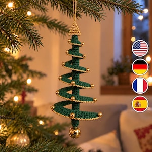 May include: A dark green crocheted spiral Christmas tree ornament featuring a gold-colored metallic bell at the base and small gold beads spaced along the edges of the spiral. The ornament hangs from a gold-colored string loop.