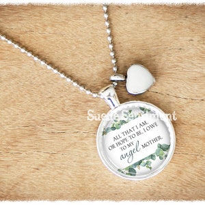 May include: Silver necklace with a round pendant featuring a floral design and the text "ALL THAT I AM. OR HOPE TO BE, I OWE TO MY angel MOTHER."