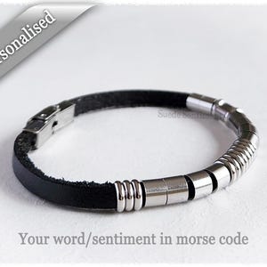 May include: A black leather bracelet with silver metal beads. The bracelet has a clasp closure and the text "Your word/sentiment in morse code" is printed below the bracelet.