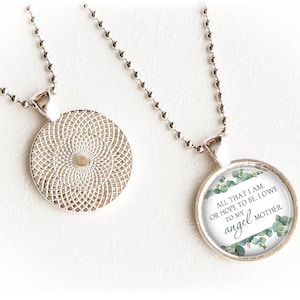 May include: Silver necklace with a round glass pendant featuring a green eucalyptus leaf design and the text "All that I am, or hope to be, I owe to my angel mother."