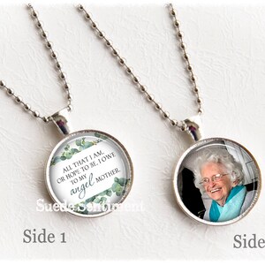 May include: A silver chain necklace with two round pendants. One pendant features a photo of an older woman smiling. The other pendant has a white background with green foliage and the text "ALL THAT I AM, OR HOPE TO BE, I OWE TO MY angel MOTHER."