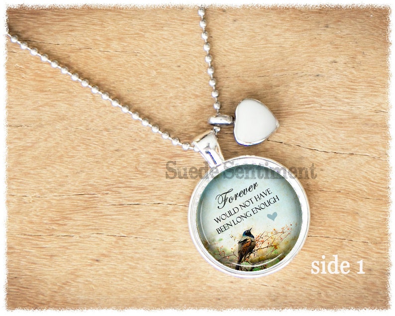 May include: Silver necklace with a round pendant featuring a blue and green image of a bird on a branch with the text "Forever would not have been long enough". The pendant also has a small heart charm.