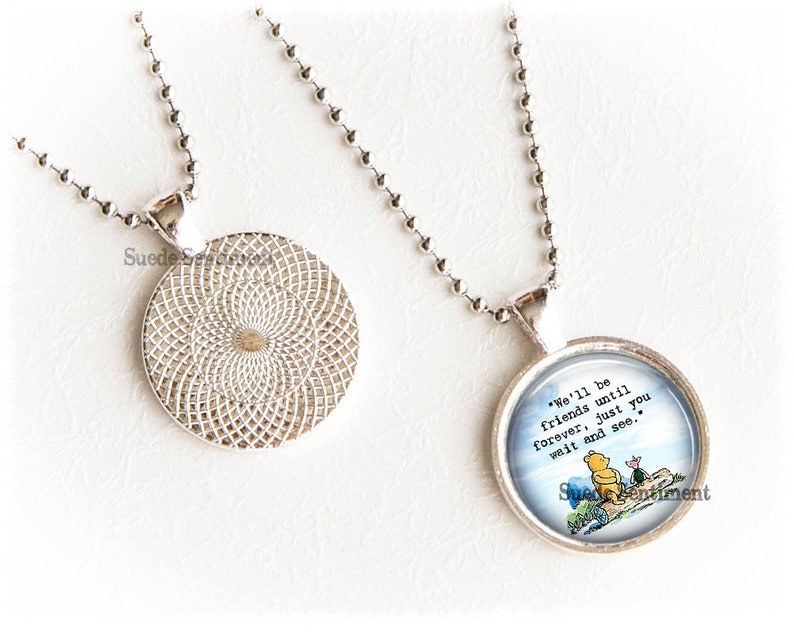 May include: A silver necklace with a round pendant featuring a Winnie the Pooh illustration and the quote "We'll be friends until forever, just you wait and see."