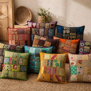 May include: A collection of square throw pillows featuring patchwork designs with various colorful fabrics, intricate embroidery, and diverse patterns. The pillows are arranged in a group, displaying a mix of red, green, blue, yellow, and orange tones.
