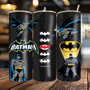 Puede incluir: Un vaso cilíndrico negro con pajita que presenta gráficos de Batman. El diseño incluye a Batman en vuelo, poses de pie, el logotipo de Batman y una columna vertical de símbolos de murciélago con el texto I AM BATMAN en letras blancas.