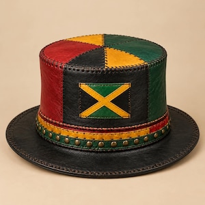 Puede incluir: Un sombrero de copa construido con paneles de cuero rojo, amarillo, verde y negro. La corona presenta un parche rectangular con una cruz de San Andrés amarilla sobre fondo verde y negro. Una banda con tachuelas metálicas rodea la base.