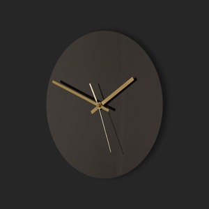 May include: A black round clock with gold hands on a black background.