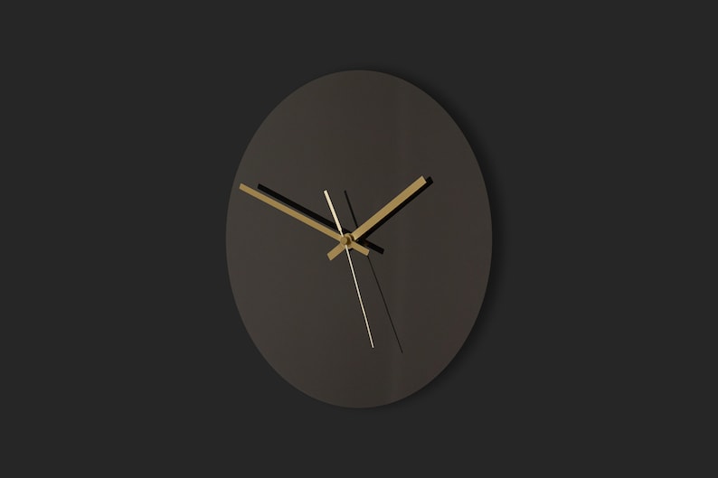 May include: A black round clock with gold hands on a black background.