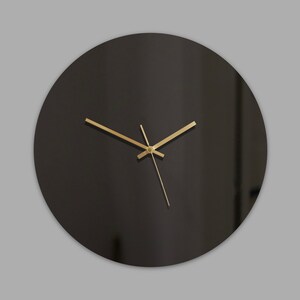 May include: A black round clock with gold hands.
