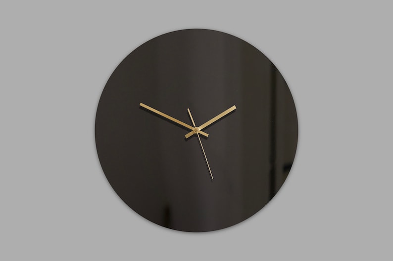 May include: A black round clock with gold hands.