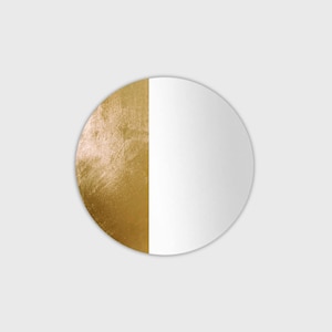 Könnte beinhalten: Ein runder Spiegel mit einer goldenen Metallic-Oberfläche auf der einen Hälfte und einer weißen Oberfläche auf der anderen Hälfte.