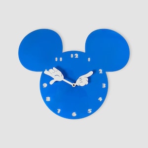 May include: Blue Mickey Mouse-shaped wall clock with white hands shaped like Mickey Mouse's hands. The clock face has white numbers 1 through 12.