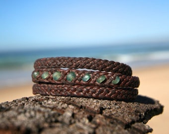 long leather bracelet featuring genuine emerald faceted stones and Tahitian pearl clasp to wrap three time around the wrist.