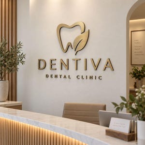 Può includere: Un'insegna a parete per Dentiva Dental Clinic con un'icona a forma di dente e foglia in metallo color oro sopra la scritta DENTIVA DENTAL CLINIC in lettere dorate. L'insegna è esposta su una parete liscia di colore chiaro in un'area reception.